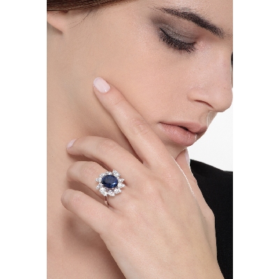 Anillo halo en oro blanco de 18k con un zafiro azul talla ovalada y diamantes