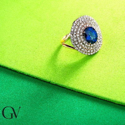 Anillo halo en oro rosa de 18k con zafiros azules y diamantes
