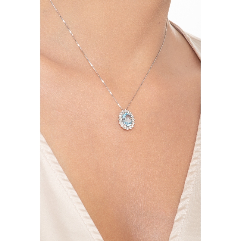 Collar halo en oro blanco 18k con colgante de aguamarina ovalada rodeada de diamantes Collar halo en oro blanco 18k con colgante de aguamarina ovalada rodeada de diamantes