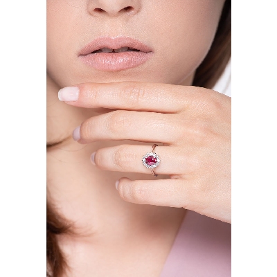 Anillo con rubí oval y halo de diamantes en oro de 18 kilates