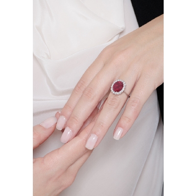 Anillo de oro blanco de 18 kilates con rubí ovalado y halo de diamantes