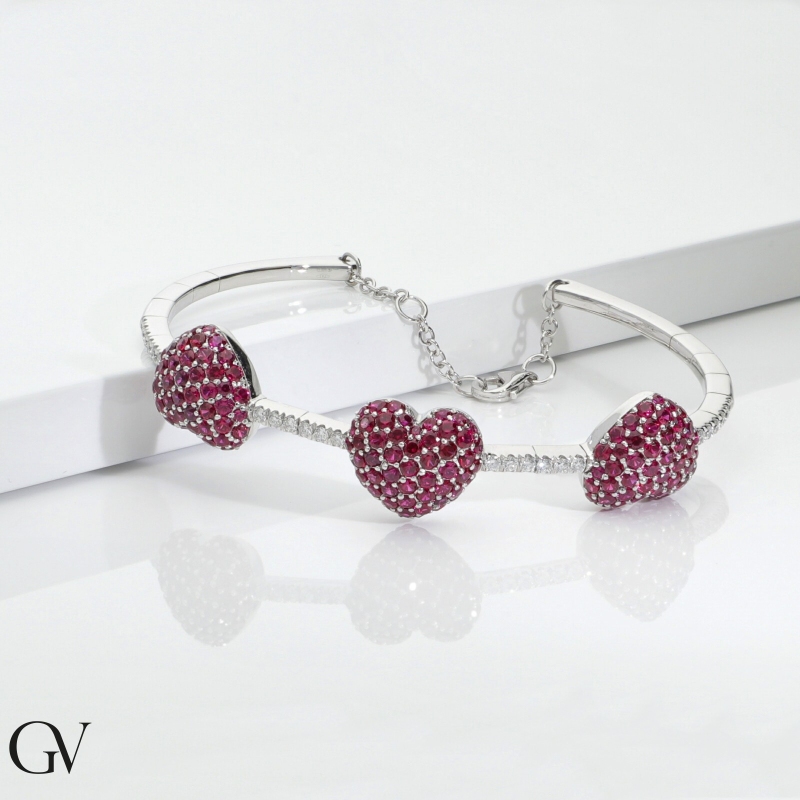 Brazalete en oro blanco 18k con 3 corazones en rubíes y diamantes  Brazalete en oro blanco 18k con 3 corazones en rubíes y diamantes