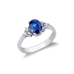 Anillo en oro blanco de 18k con diamantes laterales y zafiro azul