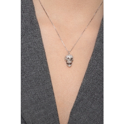 Collar de oro blanco de 18k con colgante de calavera decorado con diamantes blancos y negros